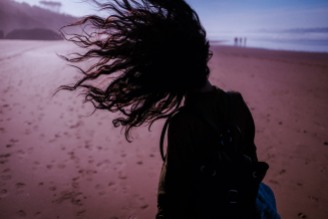 wind in girl's hair at playa do somo, on Atlantic Ocean